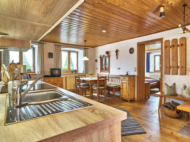 In der Ferienwohnung des Pfefferhofs verbindet sich ein gemütlicher Essbereich aus Holz mit einer modernen Küche.